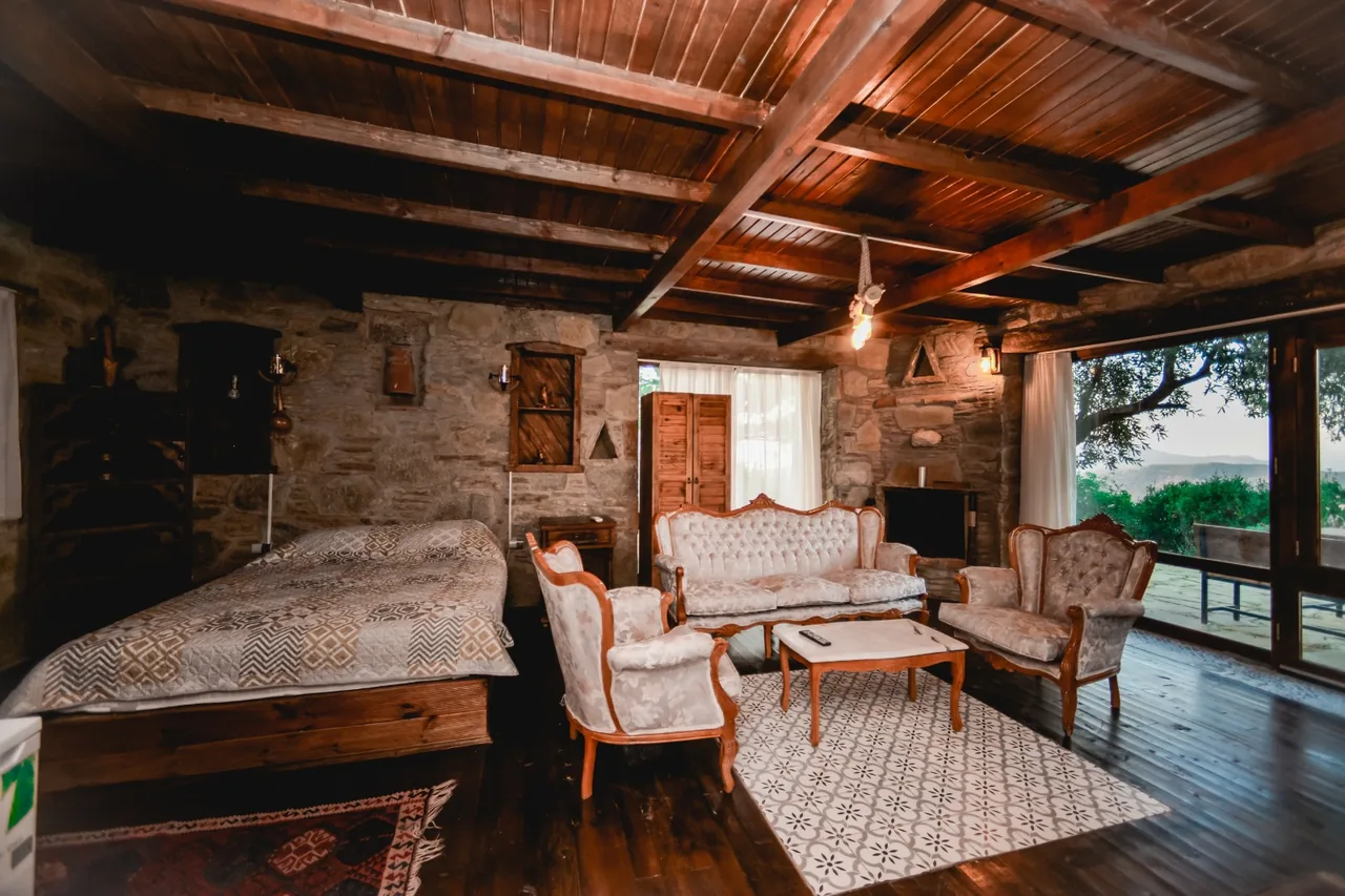 Kayalı Ev’in taş duvarları, ahşap tavanı ve açık renkli oturma alanı
